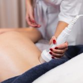 The girl in the spa salon receives a back and neck massage, lies in the cosmetology table, relaxed and enjoys the process