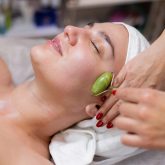 A young beautiful girl lies on the beautician's table and receives procedures, a light facial massage. Woman takes care of herself, enjoys massage